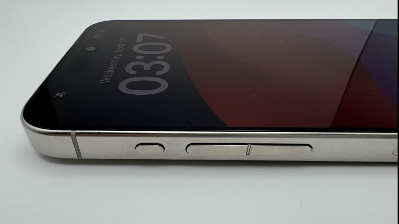 Close-up of a smartphone lying on its side, displaying 3:07 time on the screen, with visible volume and power buttons.