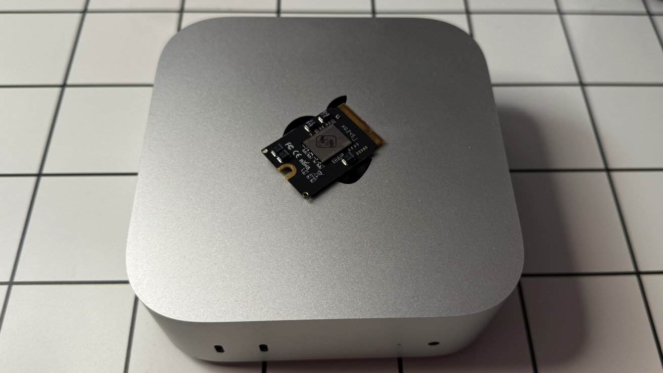 Silver square device with rounded edges on a tiled surface, featuring a small black circuit board on top.