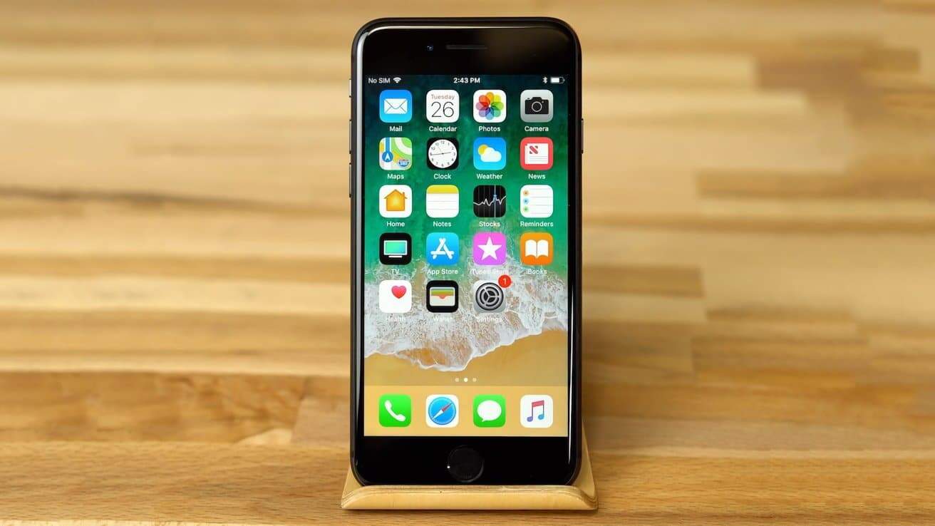 Smartphone displaying app icons on a wooden stand with a wooden background.
