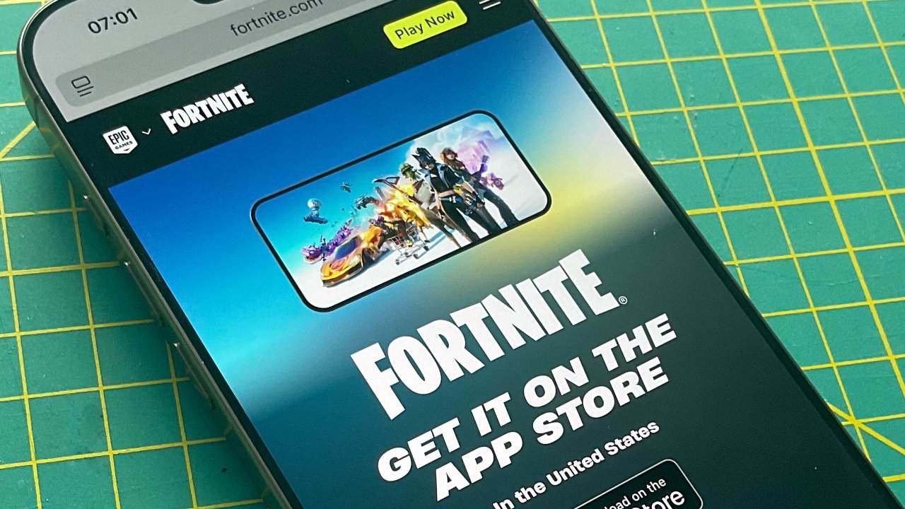 Smartphone displays Fortnite website with vibrant characters and vehicles, offering App Store availability. Background includes a green cutting mat with yellow grid lines.