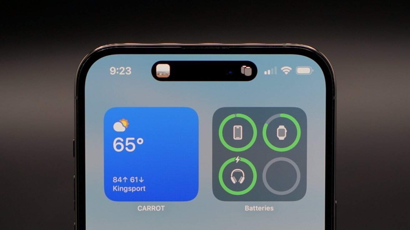 Smartphone screen displaying weather at 65 degrees, battery widgets, and time showing 9:23, with black bar at the top center.