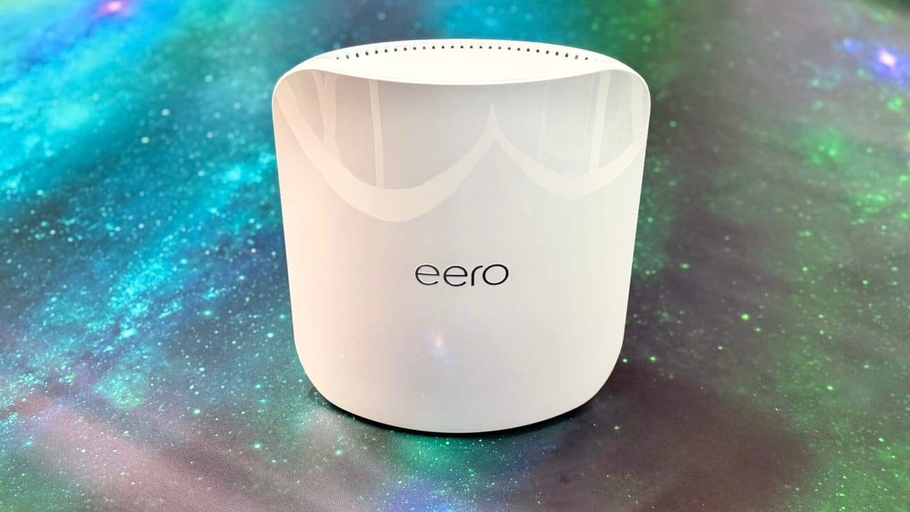 White, curved Wi-Fi router with 'eero' logo on a colorful, galaxy-patterned background.