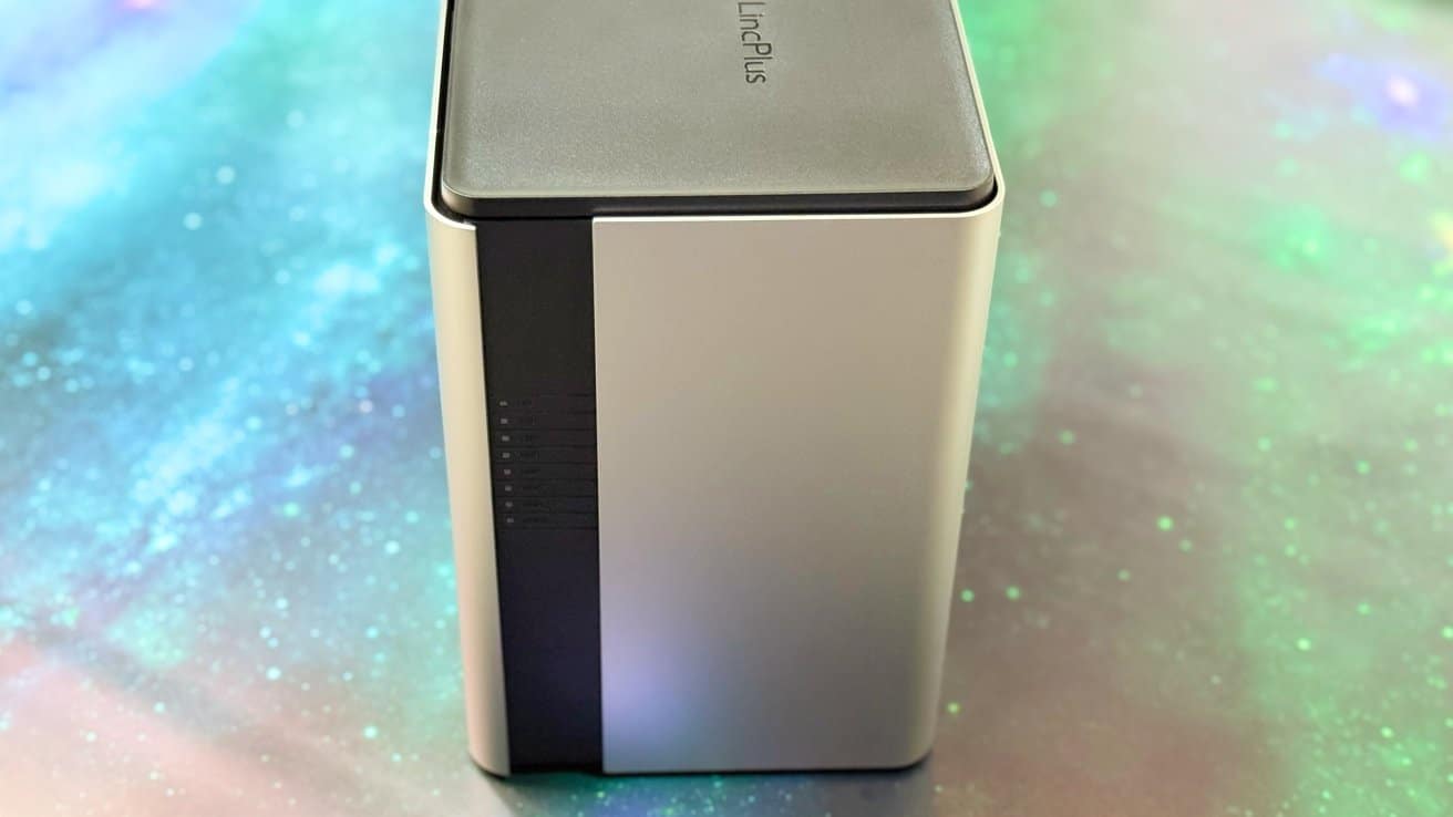 A sleek, rectangular electronic device with a black stripe and glowing indicator lights, set against a colorful, blurred background.