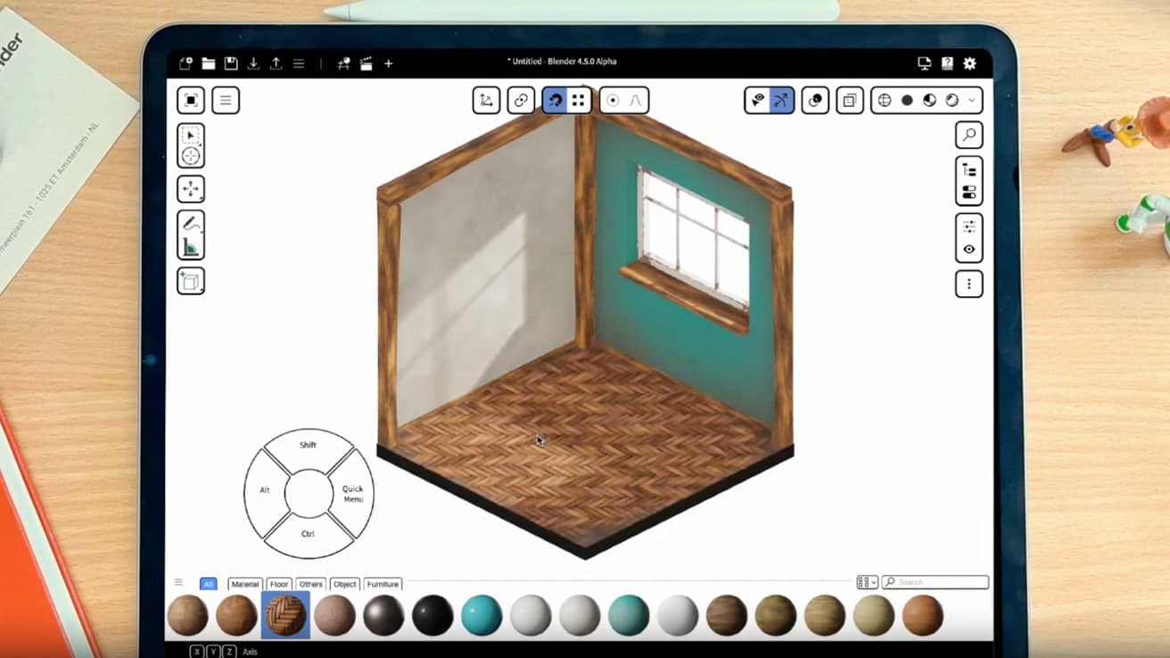 Tablet displaying a room design app with a 3D room model featuring wooden floors, window, and teal wall. Office supplies and toys are scattered on the desk.