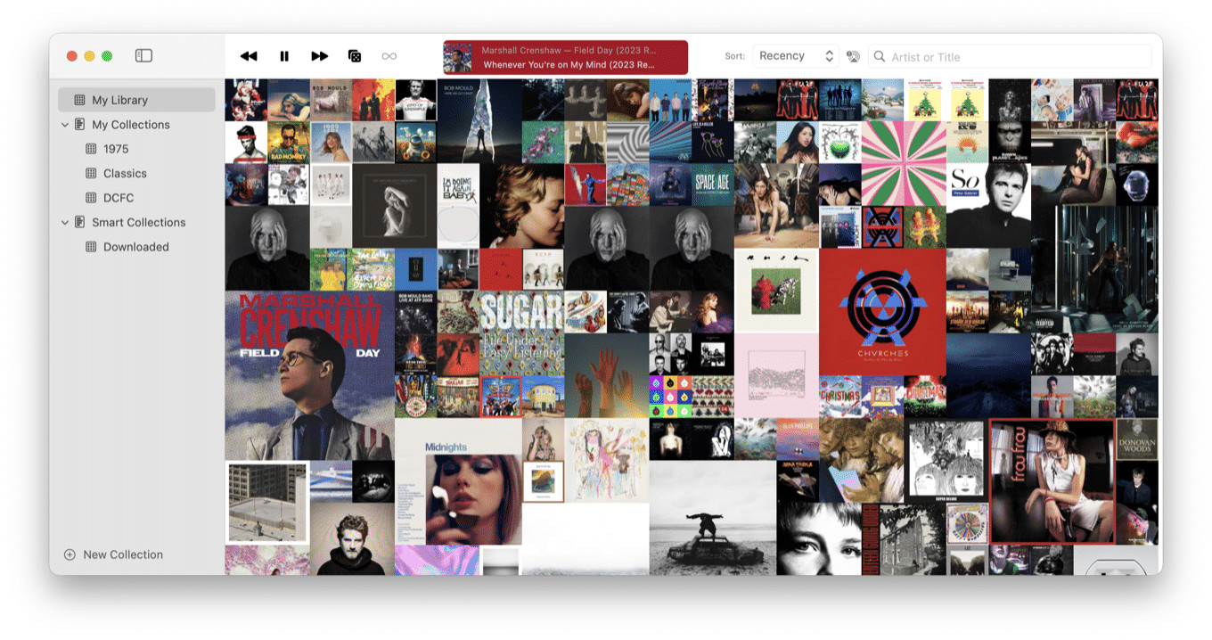 A music library interface displays a grid of album covers. The top of the screen shows playback controls and sorting options.