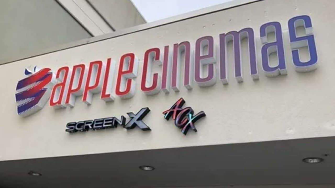 Building signage reads 'Apple Cinemas' with logos for ScreenX and ACX on a light-colored wall.