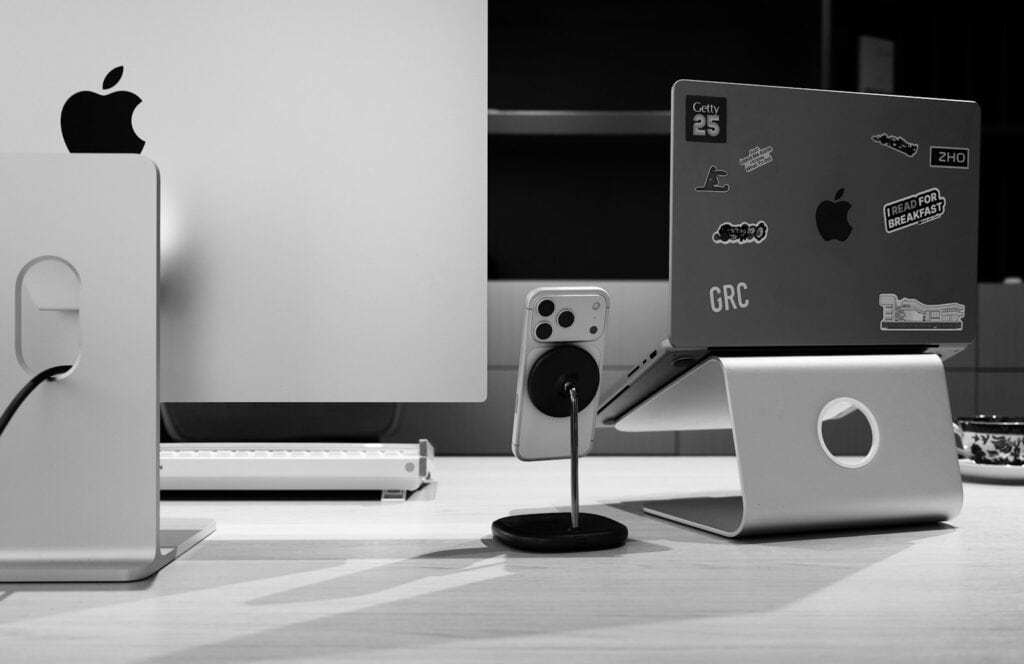 Apple devices on a desk with stickers