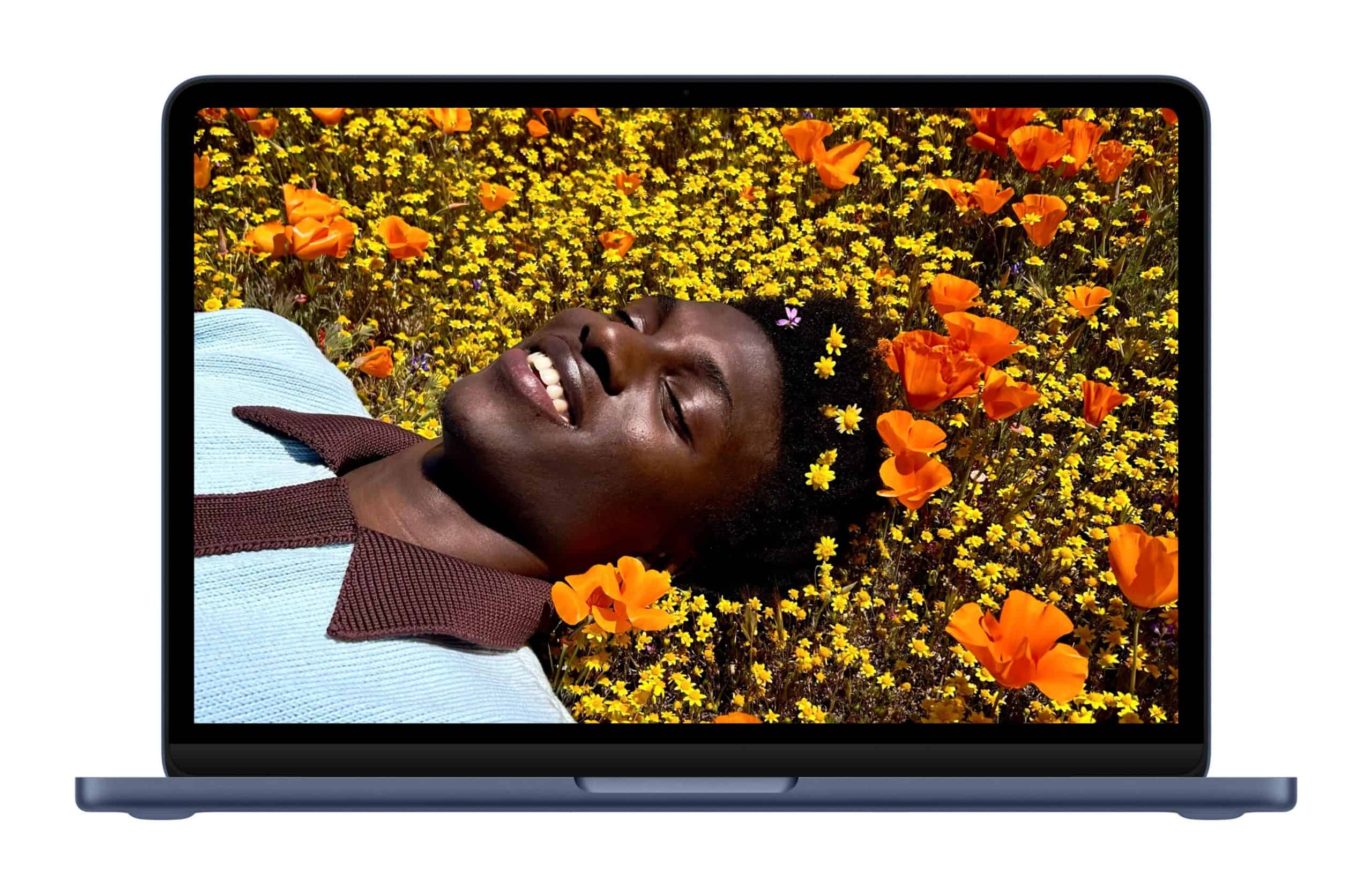 A person lying in a field of orange and yellow flowers, smiling with eyes closed.